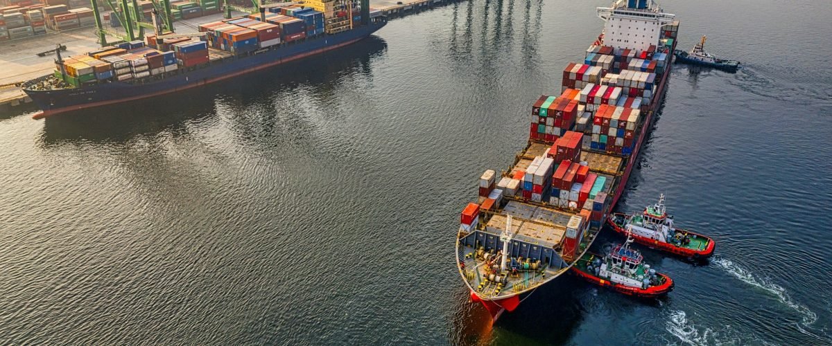 Container ship leaving port, aerial view