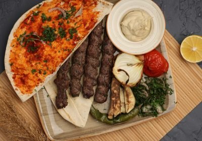 Grilled meat skewers with flatbread, grilled vegetables and dips