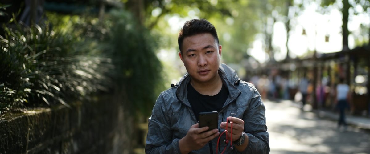 Man using his smartphone on a street in China
