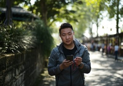 Man using his smartphone on a street in China