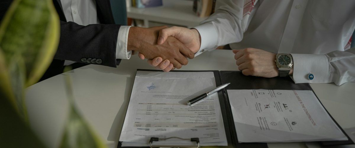Handshake over documents at a meeting table