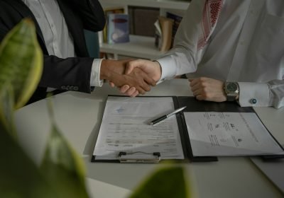 Handshake over documents at a meeting table